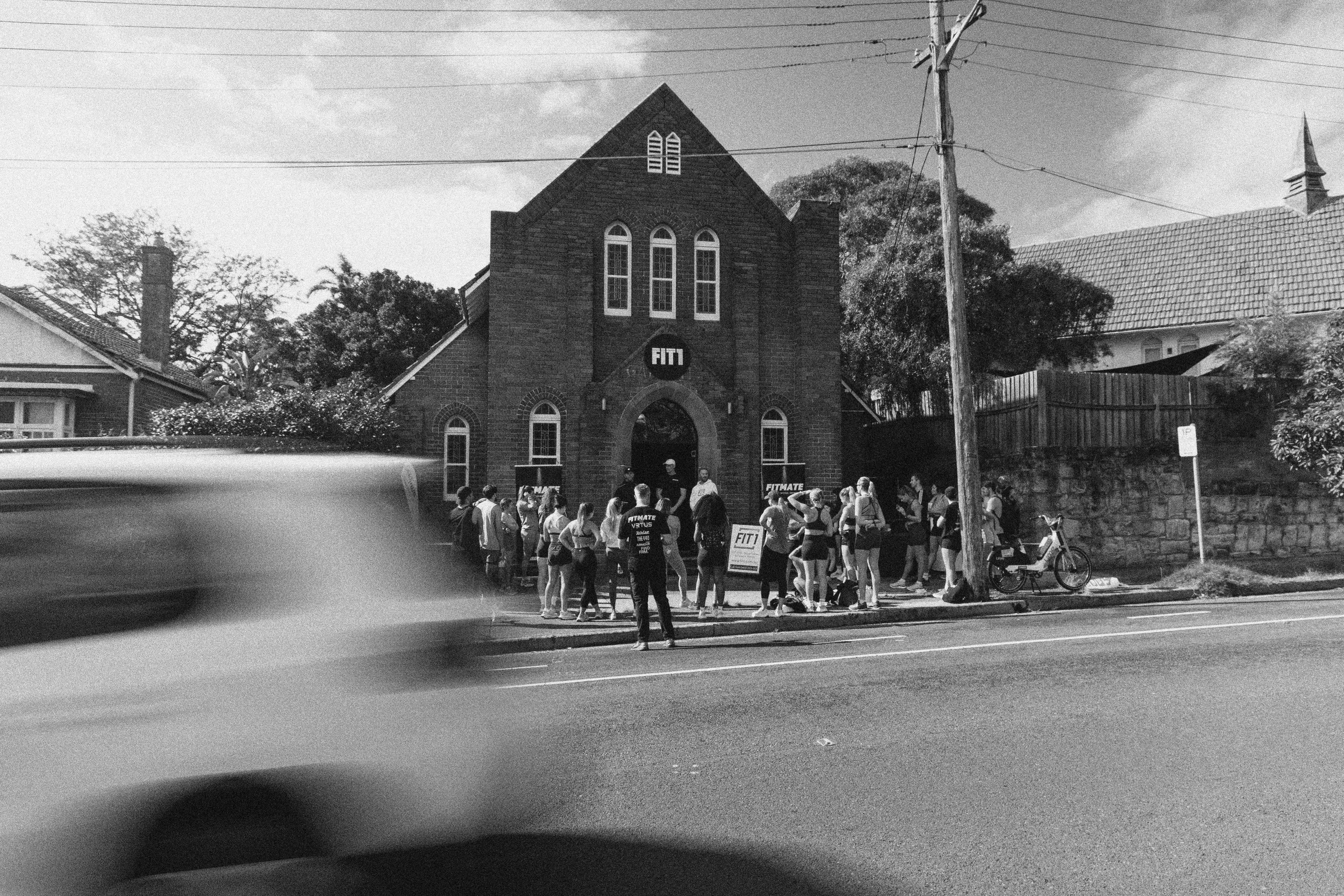 People gathered outside a historic building for a FITMATE community event
